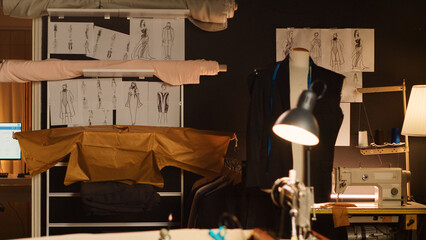 Luxury fashion atelier with sketches, sewing instruments and tools used to create custom made clothes in workshop. Empty tailoring workstations with drawings and fabric for needlework.