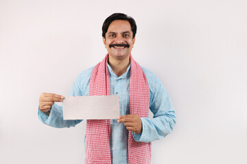 Portrait of Indian farmer in rural India concept. Standing in white background the cheerful farmer is giving a wow action, feeling proud. showing plane coupon card.