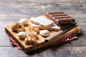 Traditional Christmas sweet, nougat and Christmas sweet almonds on wooden table