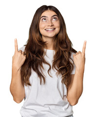 Young Caucasian woman in studio setting indicates with both fore fingers up showing a blank space.