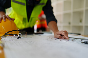 engineers discuss building on blueprint drawing, design building Project in office.