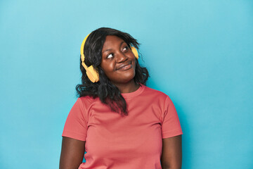 Curvy lady enjoying music in studio dreaming of achieving goals and purposes