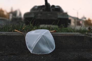 kippah cap in the Israeli flag style against background of a tracked tank. The concept of commemorating the victims of the Holocaust in World War II. The Israel Defense Forces.