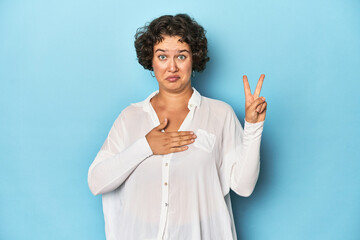 Young Caucasian woman with short hair taking an oath, putting hand on chest.