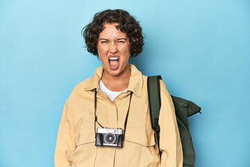 Young traveler woman with vintage camera screaming very angry and aggressive.