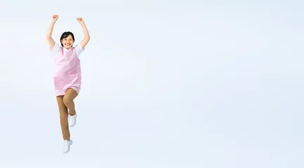 Foto op Plexiglas ジャンプするエプロンをつけた女性　保育士　介護福祉士　切り抜き全身写真（切り抜き背景透過PNGも販売しております。作成者リンクから「PNG」で検索してください） © metamorworks