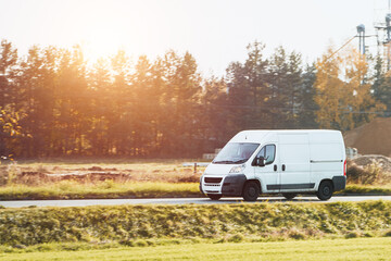 Fast-Moving White Delivery Van on Urban Highway. Distribution and Logistics in Action. Modern...