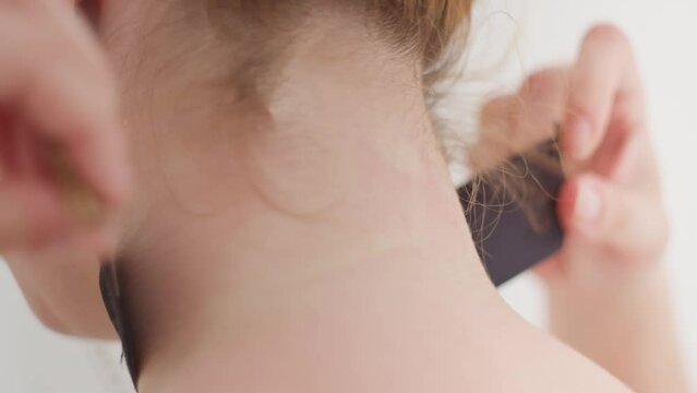 Sexy redhead taking off black choker necklace, close up back view