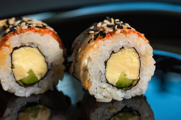 Sushi rolls with sesame seeds on a dark background close-up. Japanese food