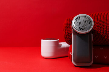 A machine for shaving fabric on clothes, on a red background.