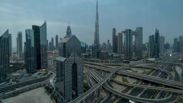 Moody night to day timelapse view of skyline of Downtown Dubai and busy Sheikh Zayed road intersection, United Arab Emirates, with clouds and rain