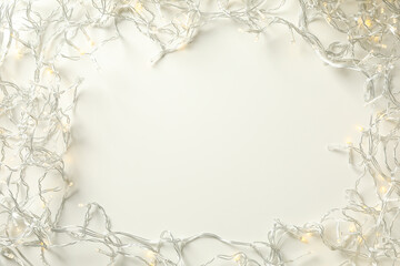 Garland with yellow lights on white background, space for text