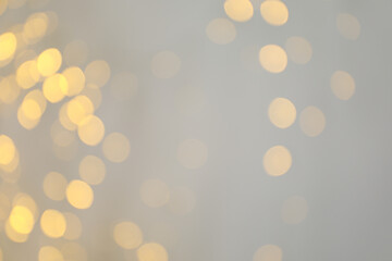 Yellow blurred lights on white background, space for text