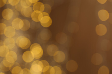 Yellow blurred lights on brown background, space for text