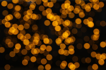 Yellow blurred lights on black background, space for text