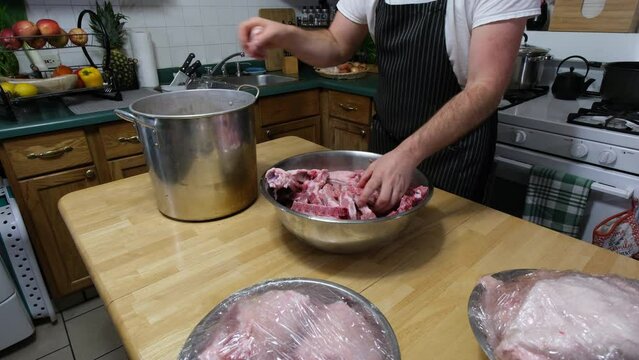 Time lapse while transferring bowl full of pork bones into large pot to be boiled for soup or broth later.