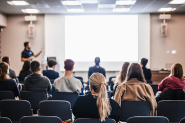 Speaker giving a talk in conference hall at business event. Rear view of unrecognizable people in audience at the conference hall. Business and entrepreneurship concept