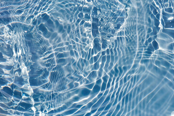 Defocus blurred transparent blue colored clear calm water surface texture with splashes reflection. Trendy abstract nature background. Water waves in sunlight with copy space. Blue watercolor shine.