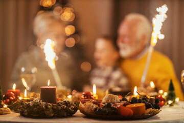 Selective focus on christmas table and christmas decorations with grandparents and grandson...