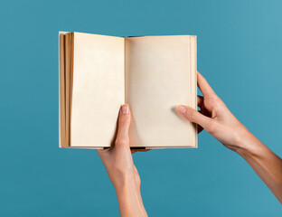 Unrecognizable young woman holding empty pages book in hands