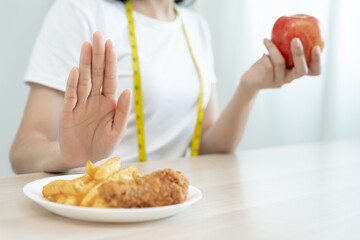 slim female body confuse French fries and fried chicken. Woman in restaurant achieves weight loss goal for healthy life, crazy about thinness, thin waist, nutritionist. Diet, body shape.
