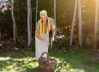 Young woman collecting tree branches in her garden on a sunny day.