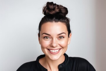 Young beautiful brunette woman with short hair and toothy smile on white background, looking at camera, close up portrait.