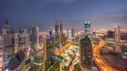 Skyline view of the high-rise buildings on Sheikh Zayed Road in Dubai aerial night to day...