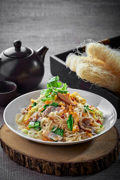 traditional chinese wok stir fried bee hoon noodle mee goreng with clam prawn seafood in plate on grey vintage background cafe hotel luxury halal food restaurant banquet menu