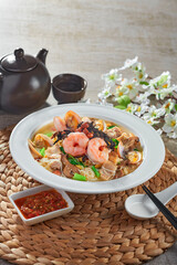 traditional chinese wok stir fried bee hoon noodle mee goreng with clam prawn seafood in plate on grey vintage background cafe hotel luxury halal food restaurant banquet menu