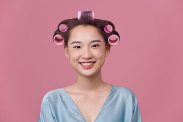 Woman with hair curlers on head wear in blue dress .