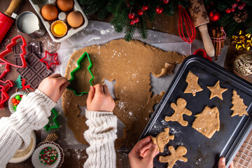 Cooking Christmas cookies family background. Mother and daughter hands top view on cozy wooden...