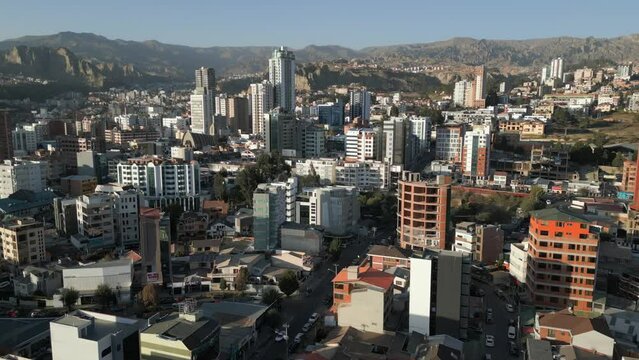 Aerial drone pan shot from right to left over bautiful cities of El Alto and La Paz along the Andes mountains in Bolivia during morning time.