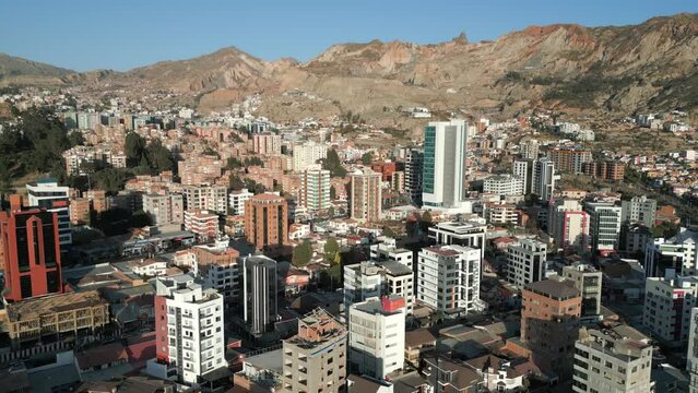 Aerial drone panning shot over city buildings of El Alto and La Paz over Andes mountains in Bolivia on a sunny morning.