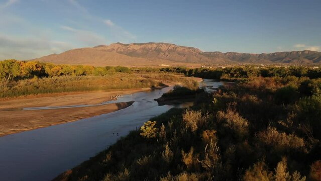Rio Grande Bosque in the Fall - Aerial over Rio Grande River with Sandia Mountains in the background, edge of Albuquerque showing next to Sandia Pueblo Lands