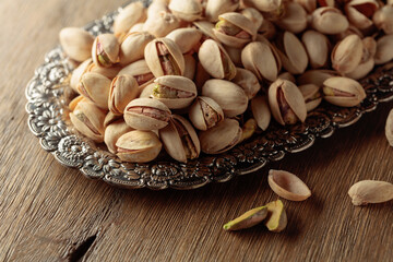 Salted pistachios on an old wooden table.