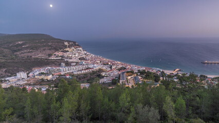 Obraz premium Aerial view of the coastline of the village of Sesimbra day to night timelapse. Portugal