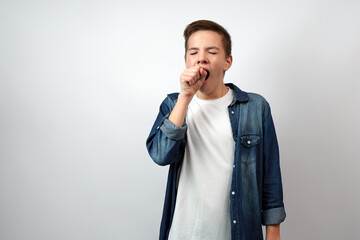 Tired school boy, yawning covering open mouth with hand - obrazy, fototapety, plakaty