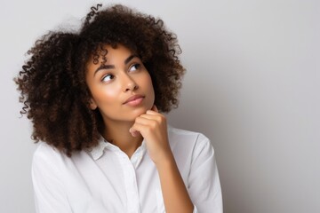 young African American woman with curly hair thinking