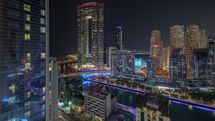 Fototapeta na wymiar Panorama showing Dubai Marina with several boat and yachts parked in harbor and skyscrapers around canal aerial night timelapse.