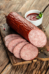 organic salami sausage on a wooden background, vertical image. top view. copy space for text