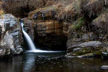 Naklejka premium A small waterfall in the middle of the forest. natural pool and waterfall. River and rocks
