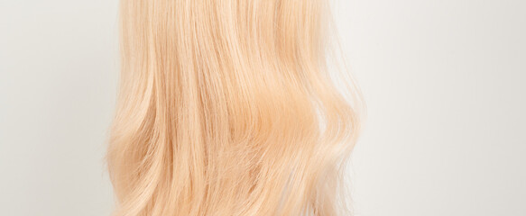 Naklejka premium Natural looking shiny hair, fair blonde curls isolated on white background with copy space