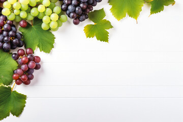 Bunch of ripe red and green grape with leaves on white wooden background top view. Background...