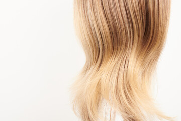 Fototapeta premium Natural looking shiny hair, fair blonde curls isolated on white background with copy space
