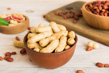 Fresh healthy peanuts in bowl on colored table background. Top view Healthy eating bertholletia concept. Super foods