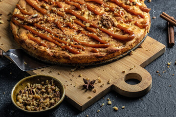 Tasty apple pie on wooden board on a dark background. top view. copy space for text