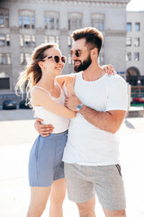 Smiling beautiful woman and her handsome boyfriend. Woman in casual summer clothes. Happy cheerful family. Female having fun. Couple posing in street at sunny day. Having tender moments. In sunglasses