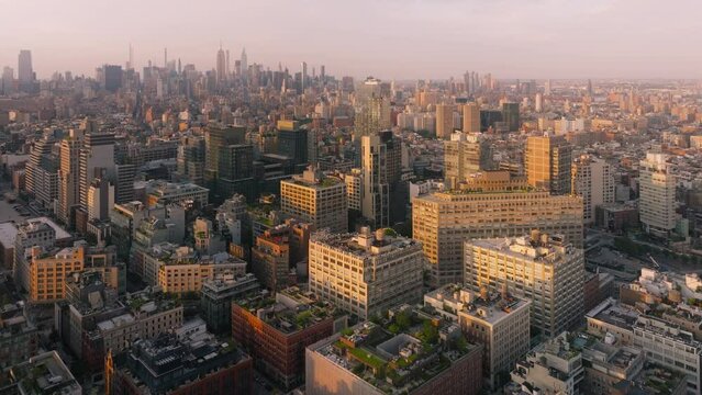 NYC cityscape travel destination in America 4K. Overhead views of prestige real estate in SOHO city district in lower Manhattan. Aerial view Manhattan streets in golden hour light of scenic sunset