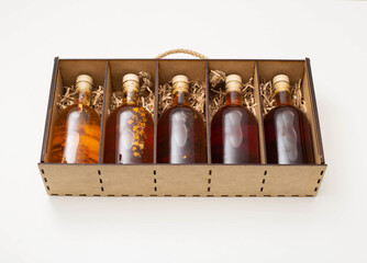 gift set of bottles with brown alcohol whiskey and brandy. Homemade herbal tincture in a wooden box...